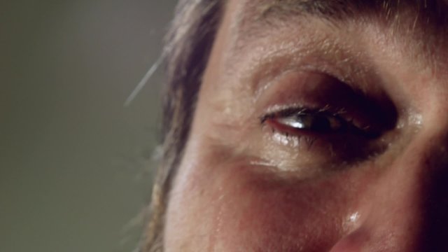 Crying man with tears in eye closeup 
