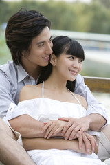 Obraz premium Young couple sitting by lake