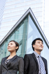 Fototapeta premium Businessman and businesswoman by building exterior