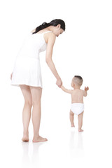 Young mother teaching baby walking