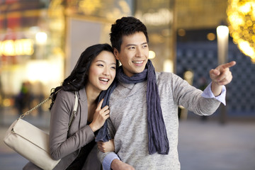 Happy young couple pointing forward