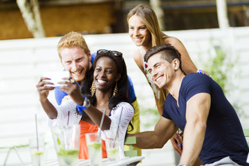 A group of friends sitting a table and talking smiling  while ta
