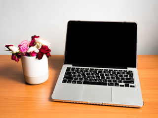 Office desk table with laptop computer and flower