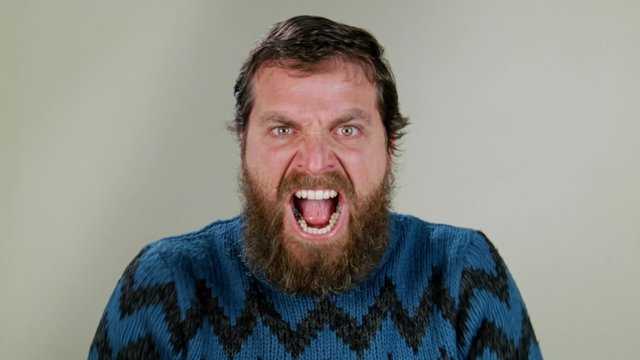 Hipster man screaming in studio on neutral background