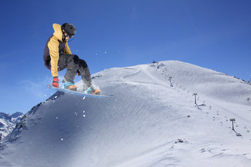 Flying snowboarder on mountains. Extreme sport.