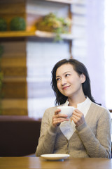 Young woman enjoying coffee in coffee shop