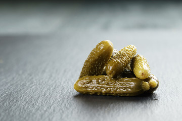 marinated cornichons on slate board