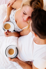 Couple in love drinking morning coffee in bed
