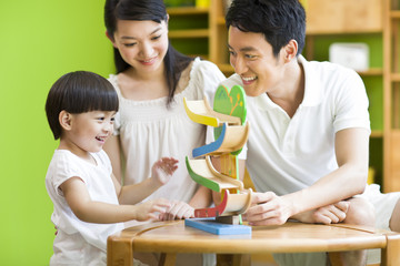 Obraz premium Young family playing toy slide