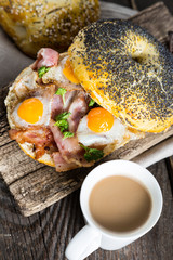 Breakfast bagel with bacon and fried quail eggs