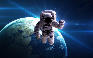 Naklejka na ściany i meble Astronaut in outer space against the backdrop of the planet. Elements of this image furnished by NASA.