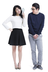 Humorous young couple with magnifying glass