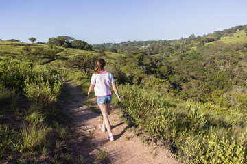 Fototapeta na wymiar Girl Hiking Wilderness footpath trail rural landscape summer.