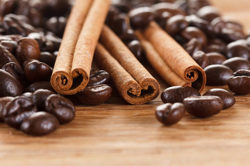Coffee beans with cinnamon and anise on wooden table