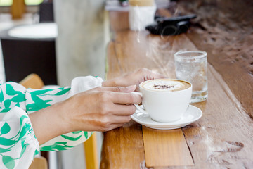 Female hand holding cup of coffee
