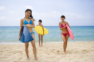 Three girls with surfboards