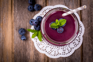 Blueberry smoothie over vintage wood table with fresh berries