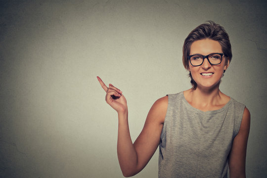 happy woman in glasses pointing with finger at blank copy space