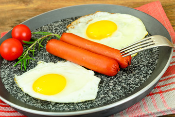 Fried eggs with fried sausages.