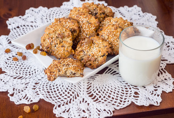 Oat biscuits and a glass of milk. Homemade cereal biscuits with the addition of sesame and raisins.