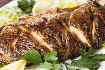 Roasted carp fish with vegetables entirely. Traditional Christmas menu.
