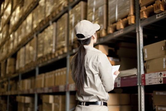 Female Chinese warehouse worker doing inventory