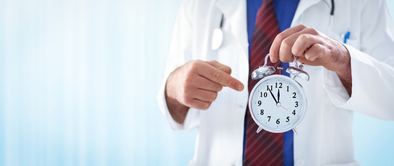 male doctor holding an alarm clock