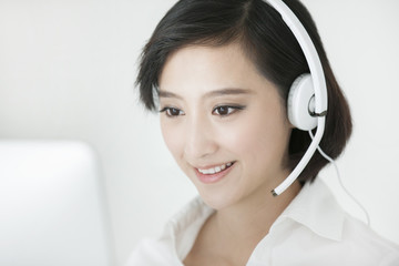 Cheerful businesswoman with headset in office
