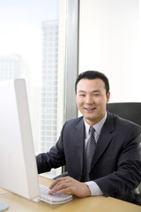 Fototapeta premium Man uses computer in a well-lit, sunny office
