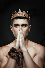 Man crown on his head to pray with folded hands.