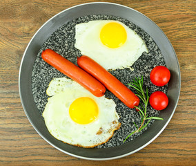 Fried eggs with fried sausages.