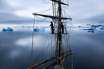 sailors aloft in a tallship in Antarctica