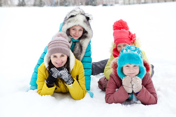 The company of cheerful happy children playing on a winter afternoon walk