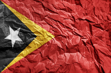 East Timor flag painted on crumpled paper background