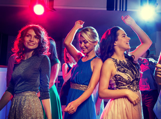 smiling friends dancing in club