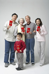 Portrait of a three generation family holding red envelopes for Chinese New Year
