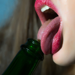 Woman licking bottle - obrazy, fototapety, plakaty