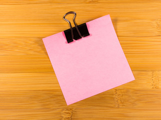 Sticky note on wooden background, empty space for text