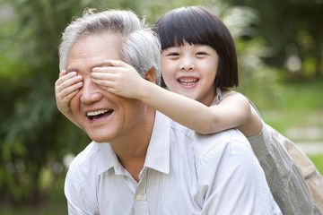 Grandpa and grandaughter having fun in garden