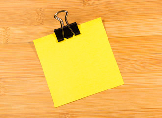 Sticky note on wooden background, empty space for text