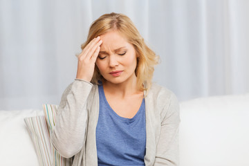 unhappy woman suffering from headache at home