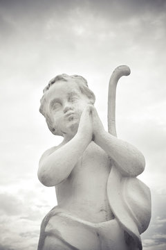 Statue of a cherub praying - image with copy space