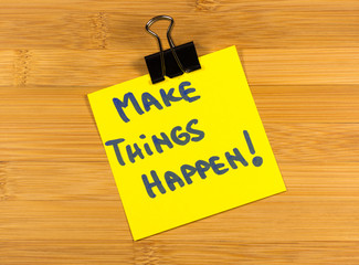 make things happen sticky note on wooden background