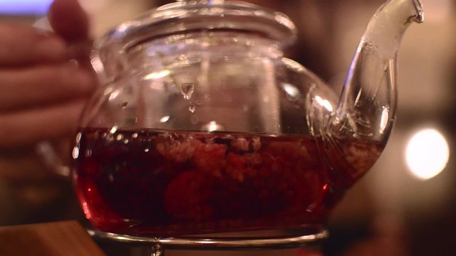 kettle with tea and berries inside