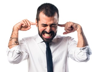 Businessman covering his ears