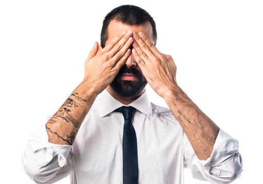 Businessman covering his eyes