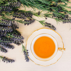 Cup of tea with flower on a wooden background top view