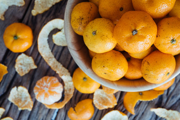 Naklejka na ściany i meble Still life of orange fruit in bowl on old wood background.