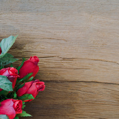 Valentine red roses on old wood background.