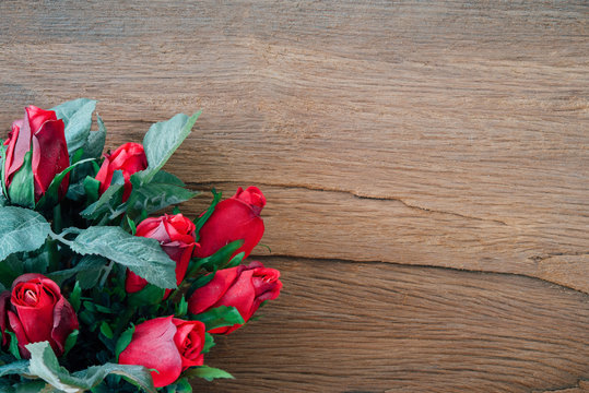Valentine red roses on old wood background.